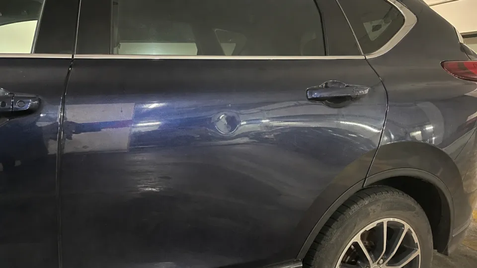 Koyu mavi SUV'un arka kapısında park çarpmasından oluşmuş yuvarlak göçük
