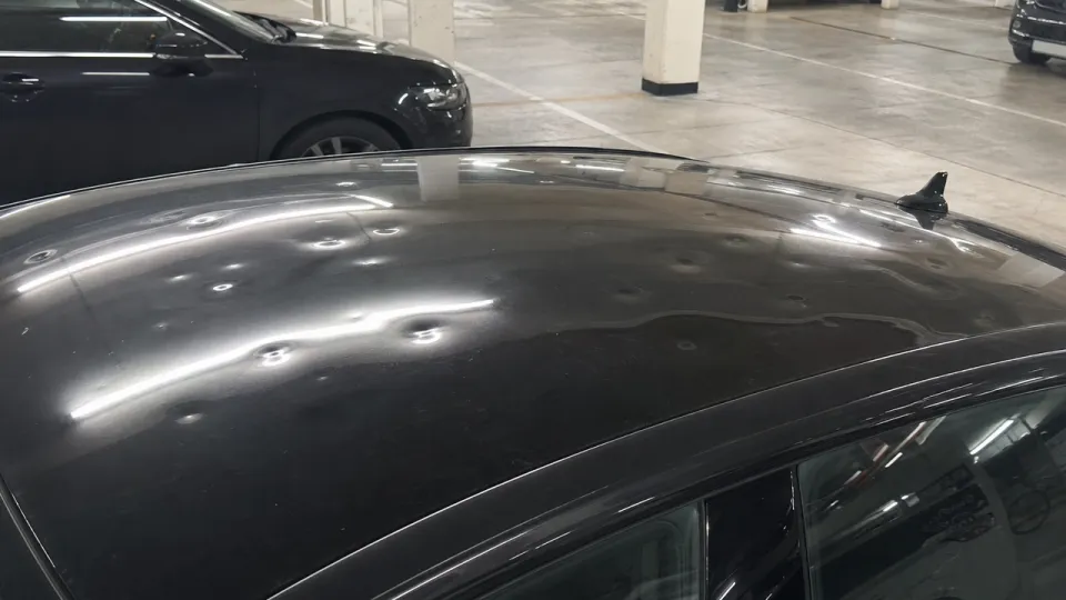 Siyah sedanın tavanında çok sayıda dolu çukuru